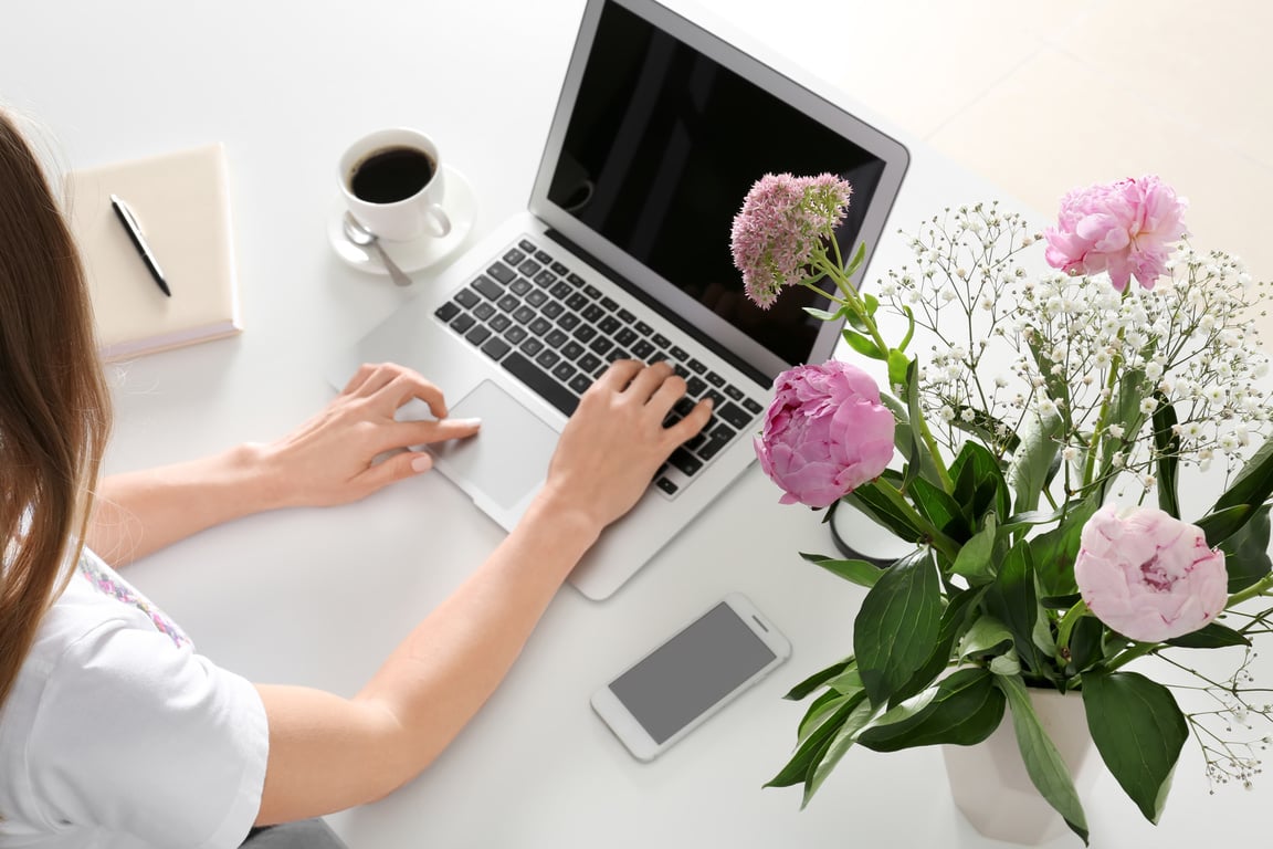 Woman Using Laptop at White Table